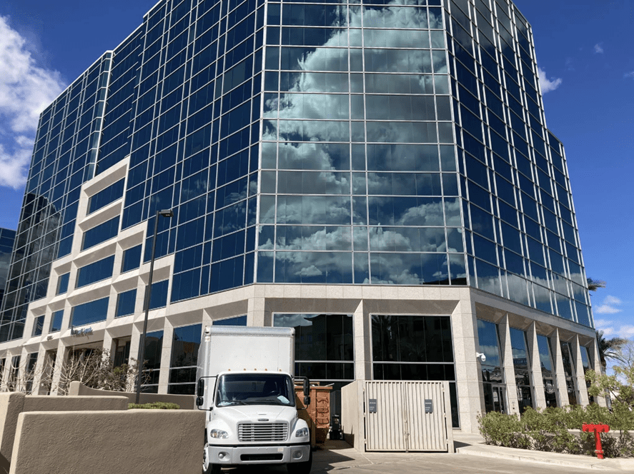 Gilbert Moving & Storage Truck outside of large commercial building